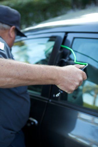 Auto locksmith working at a car door